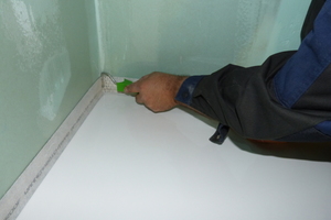  Selbst im Eckbereich ist die faltenfreie Anbringung des Abdichtbandes an der Wand – hier durch Andrücken - kein Problem. 