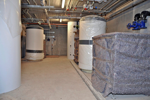  Die Technikräume im Bauabschnitt II in der Entstehung: Gut verpackt und damit vor Beschädigung geschützt kommen die Großwärmepumpen „WPF“ von Stiebel Eltron auf der Baustelle an. 