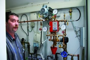  Die TestinstallationFrank Lange, Arasti GmbH, vor dem technischen Kern der Sprinkleranlage im Technikbereich des Hauses 