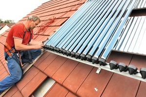  Röhren-KollektorInstallateur Peter Werner montiert die neuen Röhren-Kollektoren auf dem Dach 