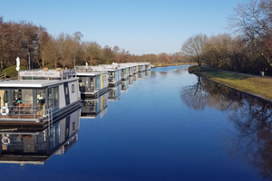  Acht schwimmende Ferienhäuser sind an der Hausboot-Marina in Bad Bederkesa fest vertäut. 