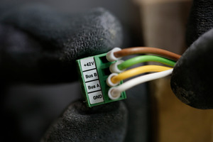 8. Elektrische Installation: Nachdem die Wärmetauschereinheit positioniert wurde, kann die Lüftereinheit in das Montagerohr geschoben werden – der elektrische Anschluss zeigt nach oben. Hier werden die gewünschte Startrichtung und Lüftungszone über den DIP-Schalter eingestellt. Das Datenleitungskabel der Steuerungsbasis wird mit der Lüftereinheit verbunden.  