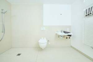  Eine breite Schiebetür trennt das Bad vom Flur. Das Bild zeigt: Der Sanitärraum ist so bemessen, dass sich hier auch Personen mit Gehhilfe oder Rollstuhl bequem bewegen können. 