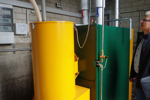  Der grüne Holzpellet-Kessel liefert modulierend zwischen 40,5 und 135 kW. Im Vordergrund der Vorratsbehälter mit Saugturbine des Entnahmesystems (gelb). 