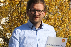  Produktmanager, Thomas Moser, mit der Broschüre „HDG Pellet-Leitfaden“ 