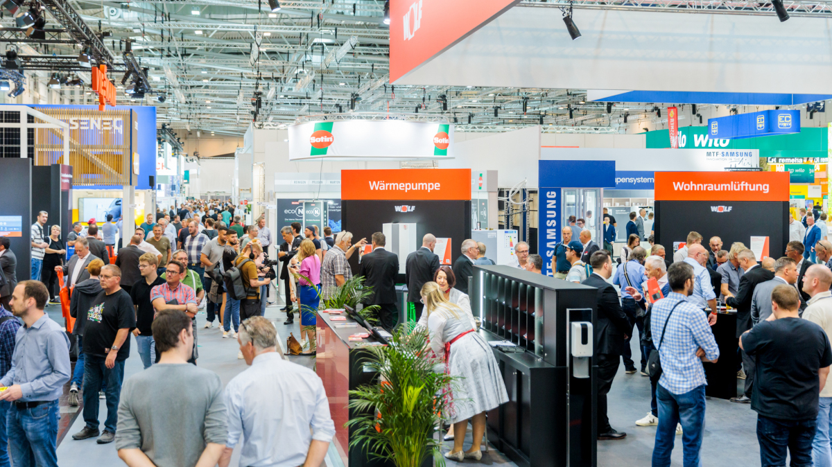 Viele Menschen gehen in der Messehalle umher, überall sind Messestände.