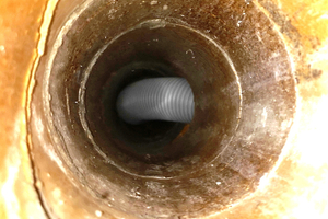  Flexible Abgasleitungen im Schacht von unten fotografiert. Stützbogen und Auflageschienen fehlen – unzulässiger 90°-Verzug! 