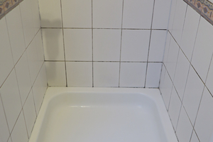  Die komplett geflieste Dusche im Bestand mit den Gebrauchsspuren der Jahre, Duschabtrennung und Brausestange sind bereits entfernt. 