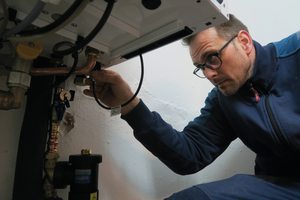  Auf der Unterseite des Gerätes führt der erfahrene Monteur die L-Bus-Leitung vom „Kit 65“ in das Regelungsgehäuse des Gas-Brennwertkessels und verbindet sie dann mit der innen liegenden Platine. 