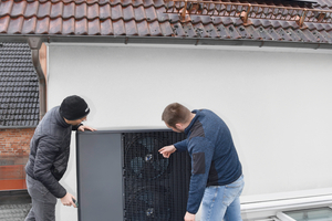  Regelmäßige Überprüfung: Feldtest-Teilnehmer Nikolas Schröder (rechts), selbst Wärmepumpen-Entwickler, und sein Vorgesetzter Marius Holtdirk haben die „WPL-A“, die auf dem Garagendach des Bestandsgebäudes installiert wurde, regelmäßig genauestens unter die Lupe genommen – insbesondere bei widrigen Wetterbedingungen, wenn die Wärmepumpe am stärksten gefragt ist. 