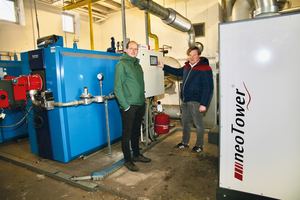  In der Heizzentrale stehen Markus Wiechmann vom Bauamt der Gemeinde Barßel (links) und Alexander Feye, Vertrieb Deutschland Nord-West bei RMB/Energie am Gasheizkessel von Buderus. Im Vordergrund: der „neoTower 50.0“. Für mehr Deckenhöhe hat der Raum ein abgesenktes Bodenniveau. 