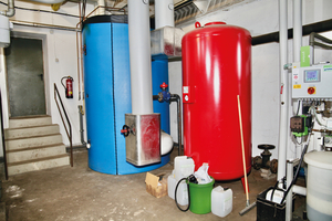  Vom 5.500 l fassenden Pufferspeicher (blau) wird die von den verschiedenen Wärmeerzeugern eingespeiste Wärme ins Nahwärmenetz geliefert. Davor ist das Membranausdehnungsgefäß (rot) zu sehen. 