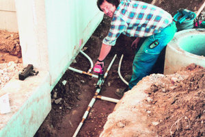  links:SanitäranlagenEin Schomberg-Mitarbeiter schließt auf der Baustelle die Sanitäranlagen an die Ver- und Entsorgungsleitungen des Stadions an 