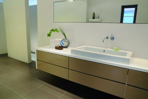  Raum-im-Raum-KonzeptIn der Nische neben dem Waschtisch befindet sich die Dusche, die durch eine freistehende Wand vom übrigen Bad abgetrennt ist 