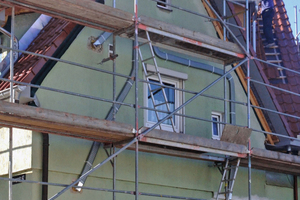  Das Gebäude während der Bauzeit - 
Nach den Arbeiten am Dach und dem Fensteraustausch begann die Verlegung der Lüftungskanäle auf der Fassade. 