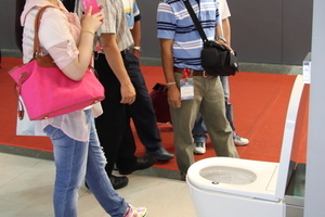  Interessierte Besucher der Messe Kitchen & Bath vor dem Dusch-WC "SensoWash i" 