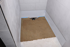  3: Der Duschbereich wird mit Estrich oder alternativ mit Mörtelsäcken aufgefüllt. Dabei wird das Gefälle des Duschboards beibehalten, um es im nächsten Arbeitsschritt problemlos einzusetzen.  