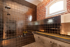  Die alten Futtertröge bilden das zentrale Gestaltungselement: Im Bad dienen sie als Waschbecken. 