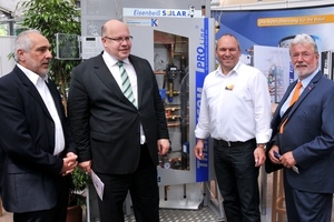  Bundesumweltminister Peter Altmaier (2. v.l.) und Handwerkskammerpräsident Jürgen Schmid (r.) informieren sich bei Johannes Hintersberger (l.) und Christian Kniele (2. v.r.) über die Thermicom-Hybridheizungstechnologie. 